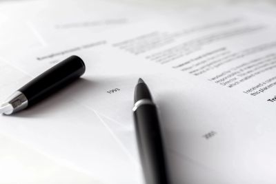 Black pen resting on contract papers.